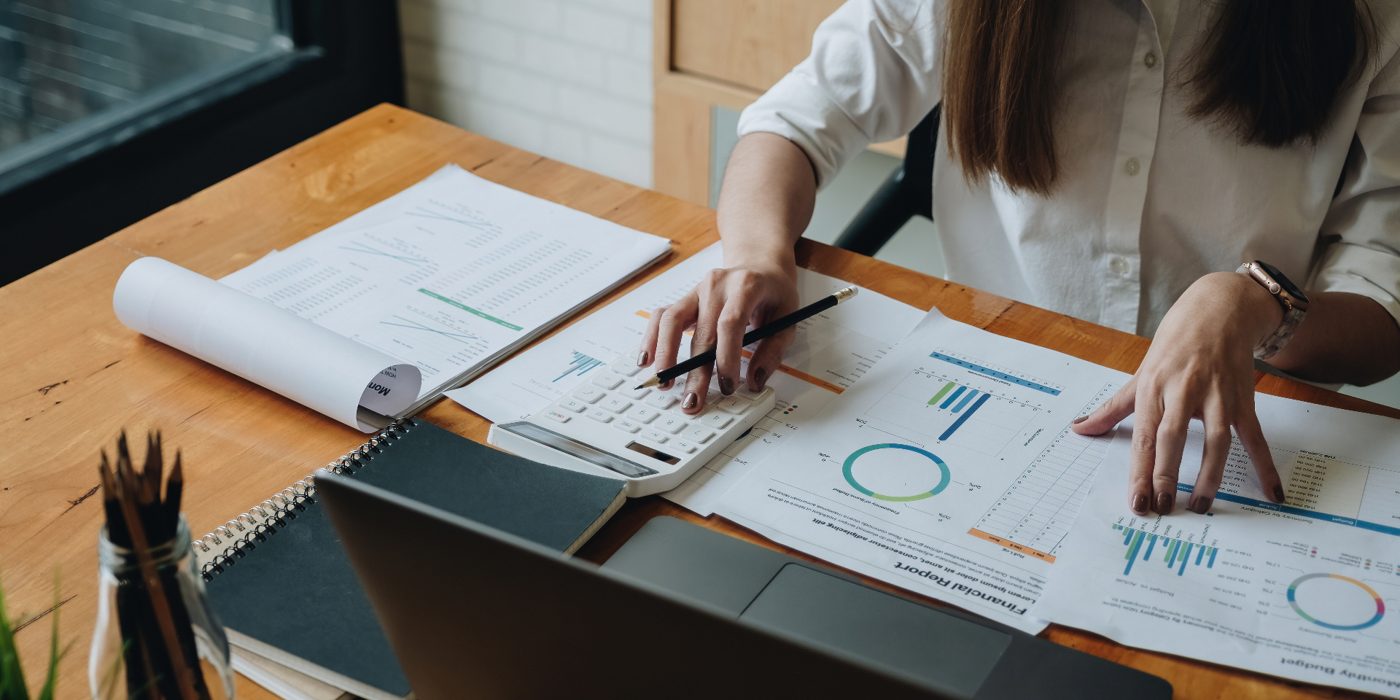 Accountant reviewing financial documents and charts at a desk